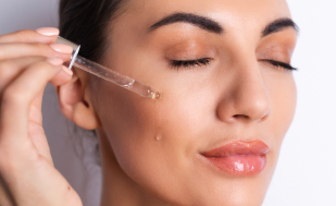 Mulher de mais ou menos 30 anos aplicando produto estético.